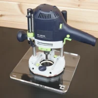 Clear acrylic square base plate attached to a Festool OF 1400 router, mounted on a ToolCurve display stand