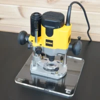 Dewalt 621 plunge router mounted on a clear acrylic square base plate, sitting on a ToolCurve display stand