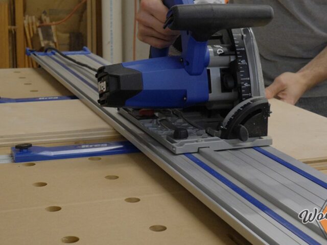 Kreg ACS plunge saw riding on its aluminum guide track during a workshop cut