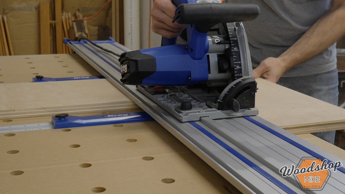 Kreg ACS plunge saw riding on its aluminum guide track during a workshop cut