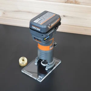 Clear acrylic 6x4 inch extended base plate mounted on a Ridgid trim router, with a brass knurled bushing beside it