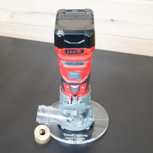 Clear 6 inch round acrylic guide bushing base plate on a Craftsman trim router, with a brass guide bushing and nut beside it